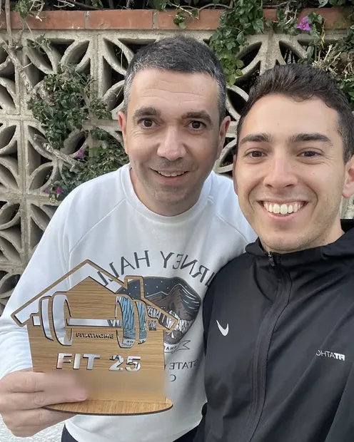 Cliente con su placa FIT 25 en el patio de su casa