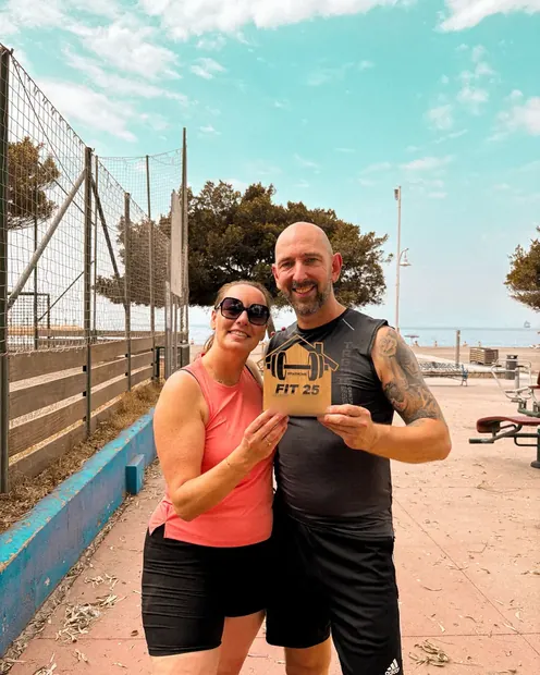 Pareja de clientes con su placa FIT 25 en una pista al aire libre